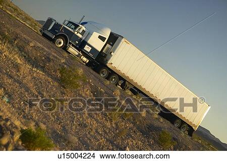 Picture - 18-wheeler semi-trucks driving down Interstate. Fotosearch