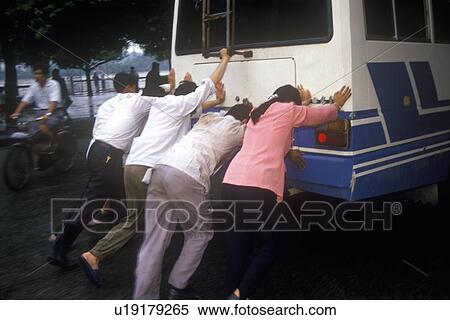 Stock Photography - People pushing bus in Guilinina. Fotosearch