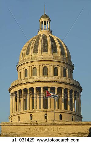 Stock Photo - Morning light on the Capitolio and Cuban Flag, the Cuban capitol building. Fotosearch