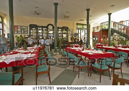 Stock Image - Red and green table settings in restaurant of Old Havana. Fotosearch