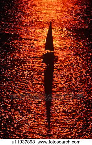 Aerial view of silhouetted sailboat at sunset View Large Photo Image Stock Photo - Aerial view of silhouetted sailboat at sunset. Fotosearch