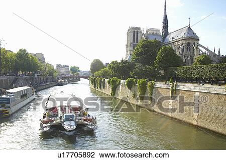 Boat on the Seine River with the Notre Dame Cathedral to the right View Large Photo Image Stock Image - Boat on the Seine River with the Notre Dame Cathedral to the right. Fotosearch