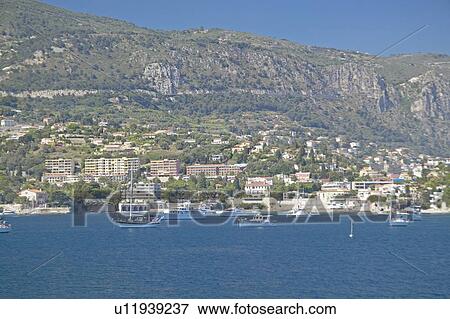 Stock Photo - Boats docked near hillside. Fotosearch