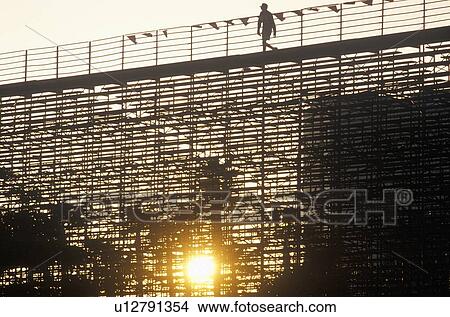 A silhouette of a person walking on the bleachers View Large Photo Image Picture - A silhouette of a person walking on the bleachers. Fotosearch