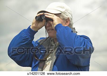 Stock Photograph - Bird watcher with binoculars. Fotosearch