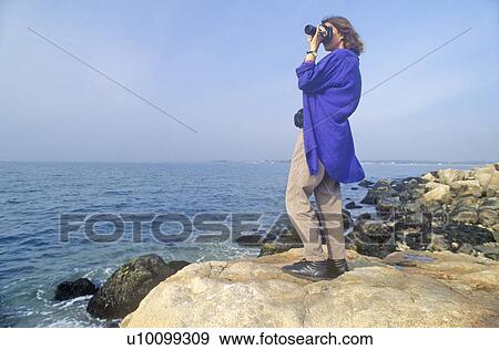 Stock Photo - Woman photographs on the rocks. Fotosearch