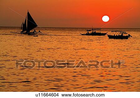 Picture - Boats traveling at the sunset. Fotosearch