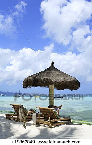 Stock Photo - People sitting on the beach chair relaxing. Fotosearch