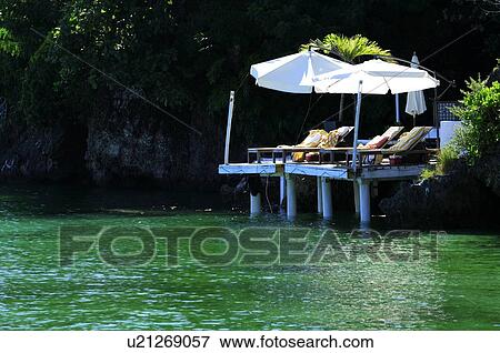 Stock Photo - Sunshade and beach chair on the corner of the Boracay island. Fotosearch