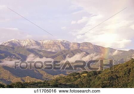 Rainbow and clouds over mountains View Large Photo Image Stock Photograph - Rainbow and clouds over mountains. Fotosearch