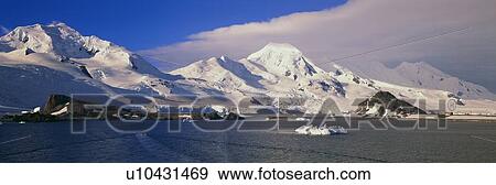 Stock Photo - Panoramic view of ecological tourists in inflatable boats, snowy mountains, glaciers and icebergs . Fotosearch