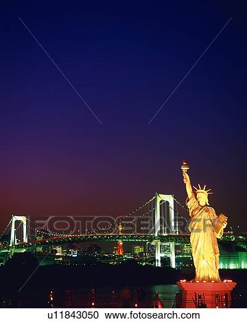 Stock Image - Statue of Liberty and rainbow bridge, night. Fotosearch