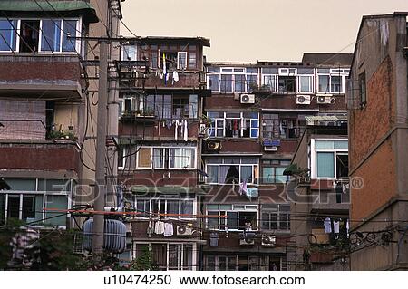 Stock Image -  a Brown-colored Apartment House, With Several Windows Under a Grey Sky, Low Angle View, Shanghai, China. Fotosearch