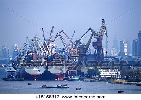 Stock Image -  a Huge Dock With Large Cranes and Several Buildings In the Background, Front View, Shanghai, China. Fotosearch