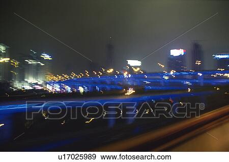 Stock Photo -  an Express Highway By Night, Surrounded By Several Different-colored Lights, Side View, Long Exposure, Blurred Motion, Shanghai, China. Fotosearch