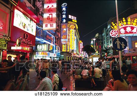 Stock Photo -  an Illuminated Street of Shanghai By Night With a Crowd of People Walking Through it, Front View, Long Exposure, Shanghai, China. Fotosearch