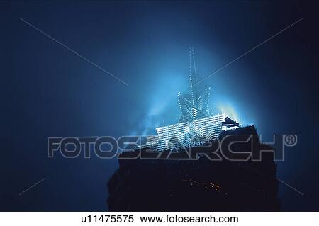 Stock Photography - Closed Up Image of the Top of the Jin Mao Tower, Illuminated in a Light Blue Color, Low Angle View, Shanghai, China. Fotosearch
