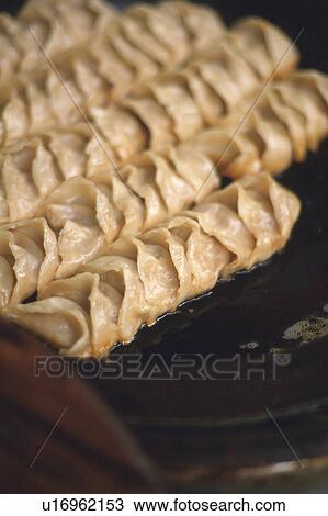 Stock Image -  Several Jiaozi on a Hot Plate, High Angle View, Shanghai, China. Fotosearch
