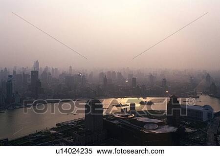 Stock Photography -  Shanghai City on a Cloudy and Foggy Day, the Water of the River Reflecting the Sunbeams, High Angle View, Far View, Shanghai, China. Fotosearch