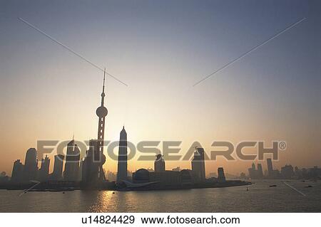 Stock Photo -  the Shanghai Buildings By Sunset, Surrounded By Ocean Water, Low Angle View, Shanghai, China. Fotosearch