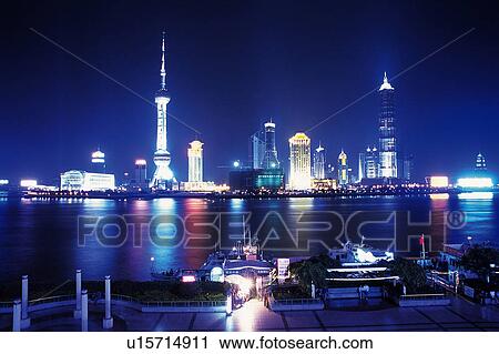 Stock Image -  the Shanghai City By Night, the Buildings By the Ocean Illuminated in Multicolored Colors, Front View, Shanghai, China. Fotosearch