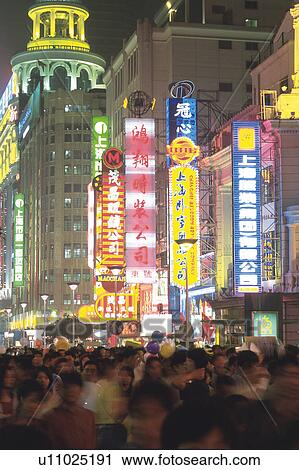 Stock Image -  the Shanghai Nightlife With a Large Group of People Walking Along the Illuminated Streets, Side View, Long Exposure. Fotosearch