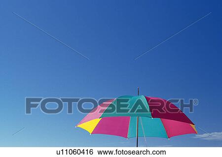 Stock Photograph -  a Colorful Sunshade Under a Blue Sky, Low Angle View, Hawaii, USA, Copy Space. Fotosearch