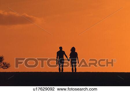 a Couple Walking Hand in Hand By Sunset, Front View, Copy Space, Hawaii, USA View Large Photo Image Stock Image -  a Couple Walking Hand in Hand By Sunset, Front View, Copy Space, Hawaii, USA. Fotosearch