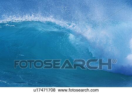 Stock Photo -  a Light Blue Ocean Wave, the Water Splashing in Many Directions, Side View, Hawaii, USA. Fotosearch