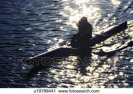 Stock Image -  a Person Riding the Canoe, the Water Sparkling, High Angle View, Lens Flare, Hawaii, USA. Fotosearch