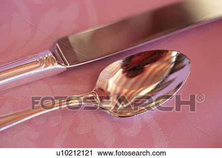 Stock Image -  a Silvern Spoon and Knife on a Pink Blanket, High Angle View, Hawaii, USA. Fotosearch