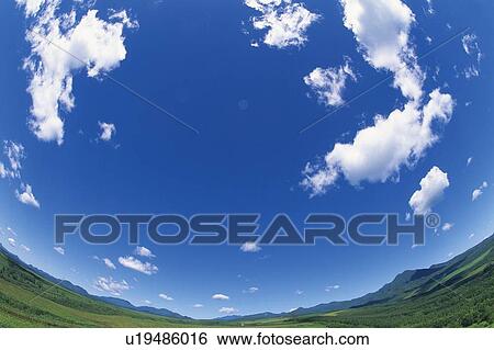 Stock Photograph -  a Huge Green Surface Under a Blue Sky and Clouds, Fish Eye, Hokkaido Prefecture, Japan. Fotosearch