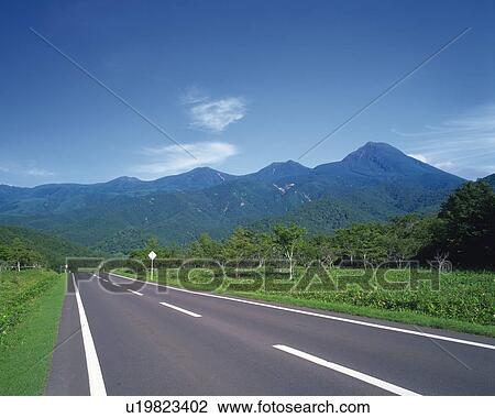 a Road, Surrounded By Mountains and Several Trees, Hokkaido Prefecture, Japan View Large Photo Image Stock Image - a Road, Surrounded By Mountains and Several Trees, Hokkaido Prefecture, Japan. Fotosearch