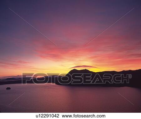 Stock Image -  Lake Mashu, By Sunset, the Water Reflecting the Colors of the Sun, Hokkaido Prefecture, Japan. Fotosearch