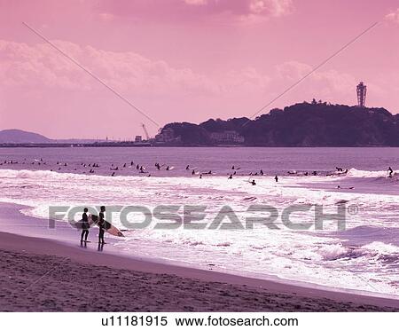 Stock Photography - Two Surfers Holding Surfboard at Tsujido Beach, Shonan, Kanagawa Prefecture, Japan, High Angle View, Toned Image. Fotosearch