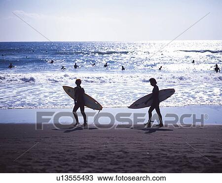 Stock Image - Two Surfers Walking at Tsujido Beach, Shonan, Kanagawa Prefecture, Japan, High Angle View, Pan Focus. Fotosearch