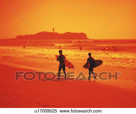 Stock Photography - Two Surfers Walking at Tsujido Beach, Shonan, Kanagawa Prefecture, Japan, Rear View, Toned Image. Fotosearch