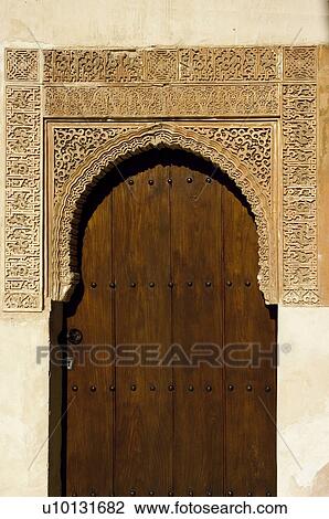 Stock Image - Ornate detailed architecture around wooden door. Fotosearch