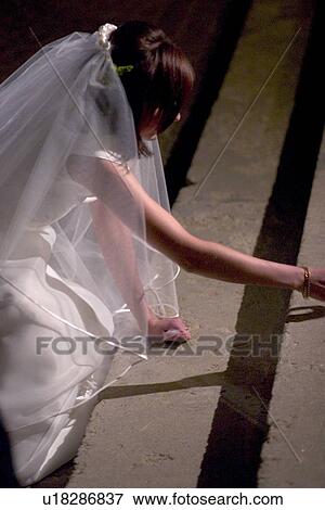 Stock Photo - Polish bride gathering coins as a ritual on church steps. Fotosearch