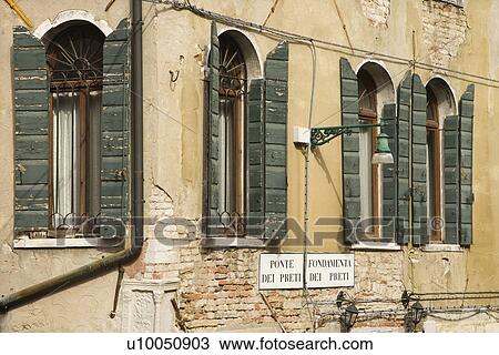 Stock Image - Arched windows with shutters in Venice, Italy.. Fotosearch