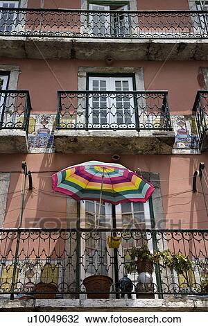 Stock Image - Building with balconies and colorful umbrella in Lisbon, Portugal.. Fotosearch