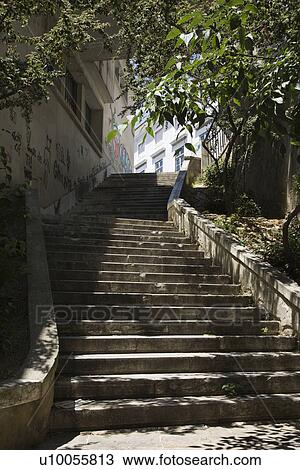 Stock Image - Sun dappled outside steps in Lisbon, Portugal.. Fotosearch