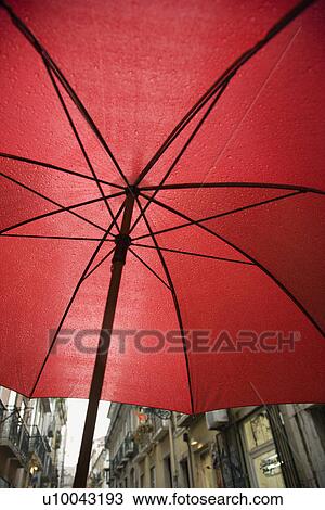 Stock Image - View from beneath red umbrella in Lisbon, Portugal.. Fotosearch