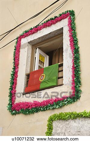 Stock Image - Window decorated with garland and flag in Lisbon, Portugal.. Fotosearch