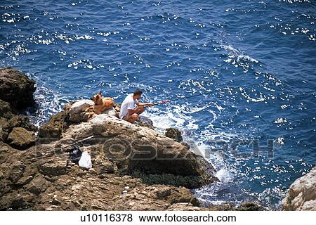 Stock Photo - Fishing from a rock -near Marseilles. Fotosearch