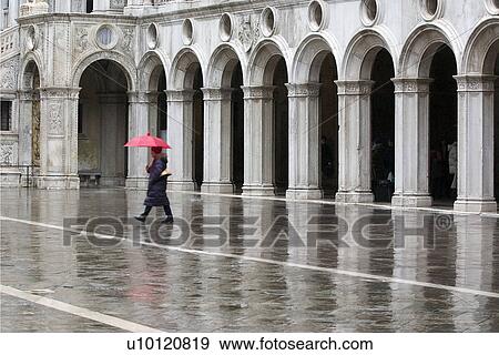 Colonnade of inside courtyard of Doges Palace and person walking in rain with umbrella View Large Photo Image Stock Photo - Colonnade of inside courtyard of Doges Palace and person walking in rain with umbrella. Fotosearch