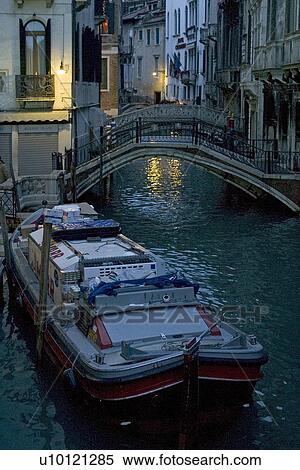 Stock Photography - Delivery barge moored at canal side making early morning delivery in semi-darkness. Fotosearch