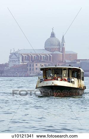Stock Image - Water bus in St Marks Basin Il Redentore (The Redeemer) church by Palladio in background. Fotosearch