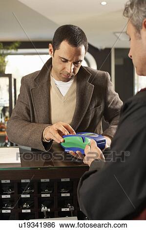 Hotel guest paying by credit card View Large Photo Image Stock Photograph - Hotel guest paying by credit card. Fotosearch