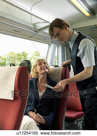 Stock Photography - Woman and conductor on train. Fotosearch